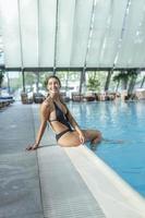 Portrait of beautiful woman in swimwear relaxing in swimming pool spa. photo