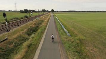 Aerial view of a cyclist riding down a long country road video