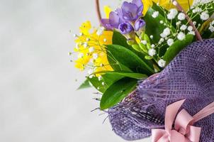 A closeup of a beautiful bouquet with purple freesia and daffodils isolated on a white background photo