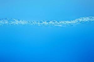 olas en la superficie del agua clara, como en el mar o en la textura de fondo del tanque de peces. foto