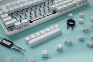 Concept of cleaning disassembled mechanical keyboard game with switch puller and key caps puller photo