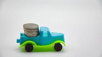 monedas de plata apiladas en camión, fondo blanco, concepto, póliza de seguro de automóvil comercial financiera foto