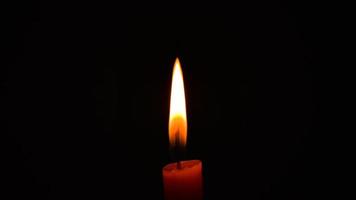 Llama de vela naranja ardiente en la oscuridad concepto de espacio de copia paz esperanza religión serenidad foto