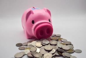 pink pig piggy bank with pile of coins on white background concept savings account savings bank financial business photo