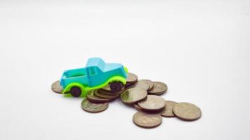 blue-green pickup truck on a pile of coins on a white background photo