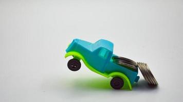 Silver coins stacked on a blue-green truck.  white background concept car insurance policy financial business photo