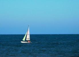 Sailboat on the blue horizon photo
