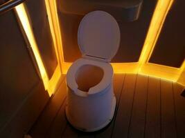 toilet in outhouse or restroom with bright orange light photo