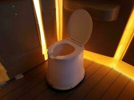 toilet in outhouse or restroom with bright orange light photo