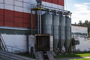 agro silos granary elevator with seeds cleaning line on agro-processing manufacturing plant for processing drying cleaning and storage of agricultural products, flour, cereals and grain. photo