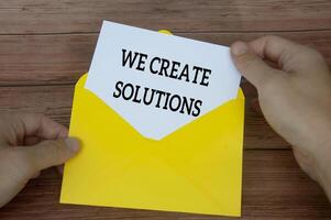 We create solutions text on white notepad in yellow envelope. Solution concept photo