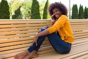 the Happy African American woman on the street talking on the phone photo