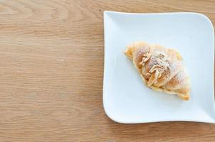 el croissant se coloca en un plato listo para comer. foto