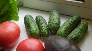 Cucumbers tomatoes avocado and other raw ingredients on table video