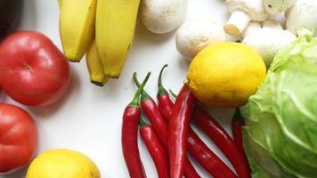 Fresh produce on white countertop including cayenne peppers lemons mushrooms and bananas video