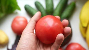 la main tient une tomate mûre video