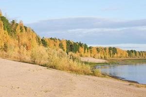 tranquila orilla pacífica del río en otoño. playa de arena de fall river, bosque de taiga siberiana. foto