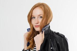 Woman beauty power. Close up of red haired girl face and leather jacket isolated on white background. Skin care, blue eyes and beautiful face. Copy space and selective focus. Redhead and no make up. photo