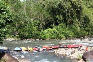 foto de actividades de rafting realizadas por un grupo de personas en un río rocoso con fuertes corrientes