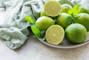 limas verdes con hojas de menta fresca en el plato foto