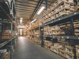 desenfoque de fondo de imagen de almacenamiento de almacén moderno de tienda minorista. interior de almacén con estantes para guardar material de producción, paletas y cajas. almacén vacío lleno de carga. foto