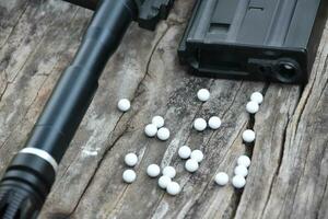 Closeup of white plastic bullets of airsoft gun or bb gun on wooden floor, soft and selective focus on white bullets. photo