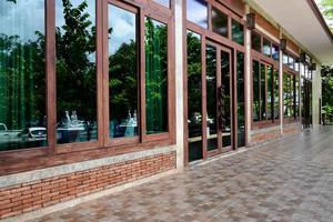 Side view of balcony window of the house made of bricks, wood and large glasses, soft and selective focus. photo