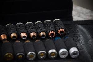 9mm pistol bullets kept in black leather pocket, selective focus on bullet. photo