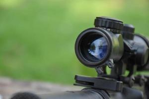 binoculares de rifle automático negro de cañón largo en el campo de entrenamiento, también conocido como pistola de aire suave o bb. use balas hechas con cuentas esféricas de plástico. enfoque suave y selectivo en binoculares.