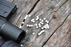 Closeup of white plastic bullets of airsoft gun or bb gun on wooden floor, soft and selective focus on white bullets. photo