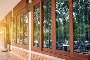 vista lateral de la ventana del balcón de la casa hecha de ladrillos, madera y vidrios grandes, enfoque suave y selectivo. foto