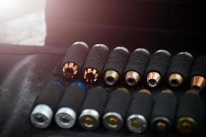 9mm pistol bullets kept in black leather pocket, selective focus on bullet.