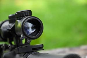 Binoculars of black automatic rifle Long-barreled at the training ground, also known as Air Soft or BB Gun. Use bullets made with spherical plastic beads. Soft and selective focus on binoculars. photo