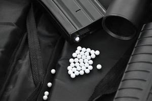 Closeup of white plastic bullets of airsoft gun or bb gun on wooden floor, soft and selective focus on white bullets. photo