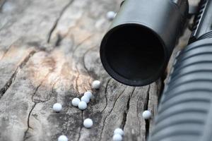 Closeup of white plastic bullets of airsoft gun or bb gun on wooden floor, soft and selective focus on white bullets. photo