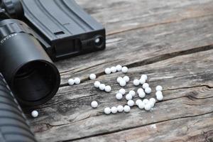 Closeup of white plastic bullets of airsoft gun or bb gun on wooden floor, soft and selective focus on white bullets. photo