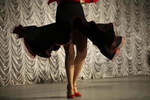 Spanish dance. Black dress. Dancer on stage. Details of speech. Incendiary movement. photo