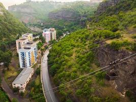 Aerial view rope way with metal buckets with load above road in Mining area in Chiatura. Transporting container. Cable railway concept. Transportation and mining Industry photo