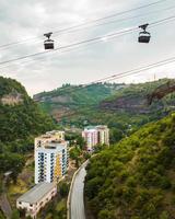 Aerial rising view ropeway with metal buckets with load above road in Mining area in Chiatura. Transporting container. Cable railway concept. Transportation and mining Industry photo