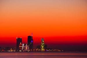 Batumi waterfront in Adjara, Georgia. Modern Architecture In Seafront Promenade In Night Or Evening Illuminations, Illuminated Resort Town Cityscape With Skyscrapers photo