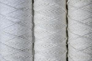 Three coils of white thread for sewing, close-up. photo