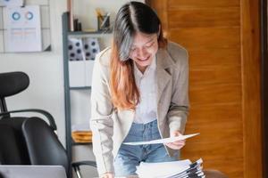 marketing, finance, accounting, planning, female accountant using laptop calculator and documents, charts, graphs in the analysis of the company's profit photo