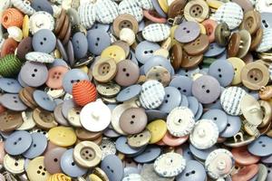 botones de costura multicolores de diferentes tamaños y formas de fondo foto