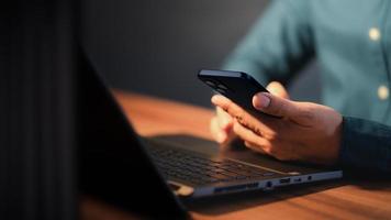 Closeup image of a man holding and using mobile phone or smartphone. photo