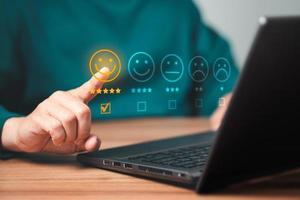 Man using a laptop in give rating to service experience on application. Online customer review satisfaction feedback survey. photo