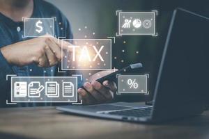 Financial tax return concept, a man's hand using a smartphone and a computer to work in accounting and tax photo