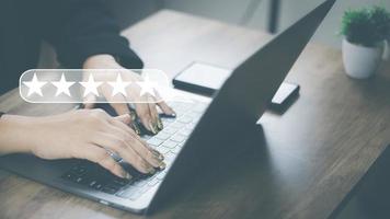Customer Satisfaction Survey Concept, A woman's hand using a smartphone gives a 5 star rating to show the highest level of satisfaction with excellent service.. photo