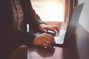 financial and investment technology concept,woman's hand using computer to analyze graphs and charts of stock market digital assets gold and oil to be in line with the volatility of the world economy photo