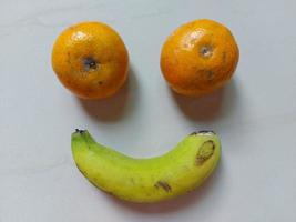 Plátano y naranja fruta aislado sobre fondo de suelo blanco foto