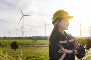 a woman engineer is putting a protective helmet on her head at sunset. photo